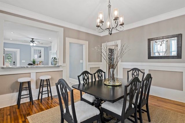 dining room featuring crown molding, dark hardwood / wood-style floors, and ceiling fan with notable chandelier