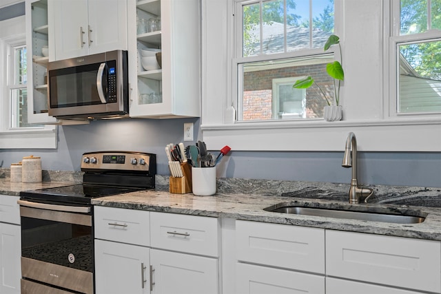 kitchen with a healthy amount of sunlight, stainless steel appliances, and white cabinetry