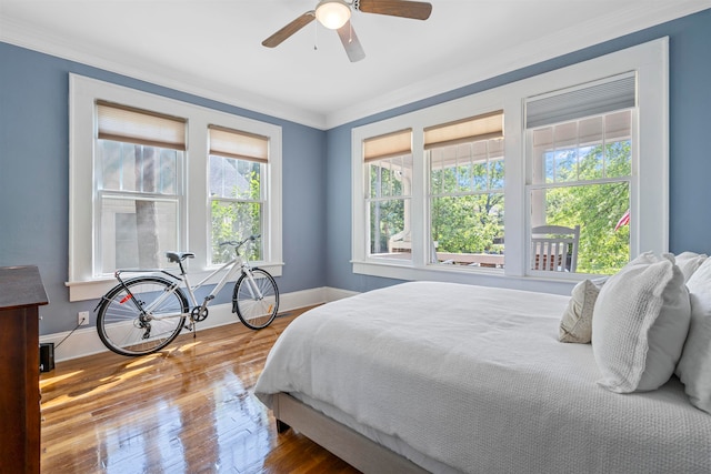 bedroom featuring ceiling fan, crown molding, and wood-type flooring