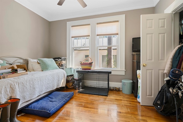 bedroom featuring crown molding, light wood-type flooring, and ceiling fan