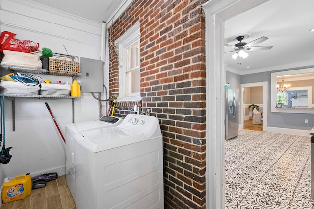 laundry room featuring light wood-type flooring, independent washer and dryer, ceiling fan with notable chandelier, crown molding, and brick wall