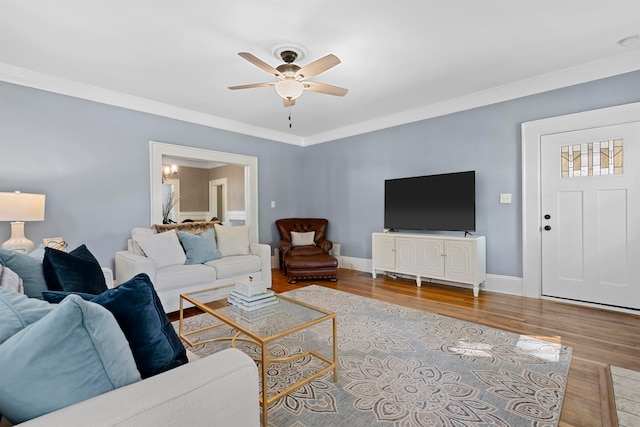 living room featuring ornamental molding, light wood-type flooring, and ceiling fan