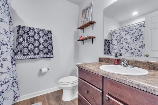 bathroom with vanity, toilet, and hardwood / wood-style floors