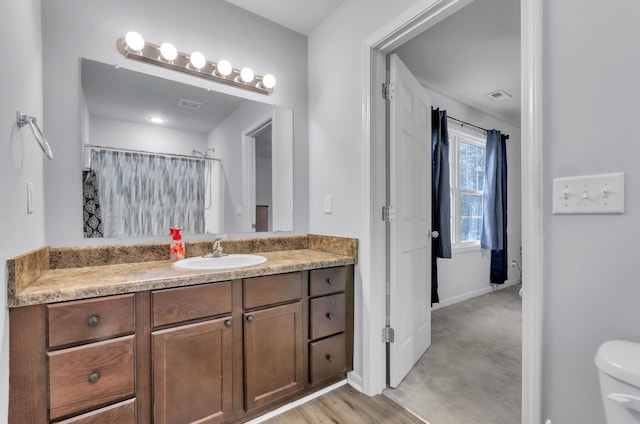 bathroom with vanity, hardwood / wood-style floors, a shower with shower curtain, and toilet