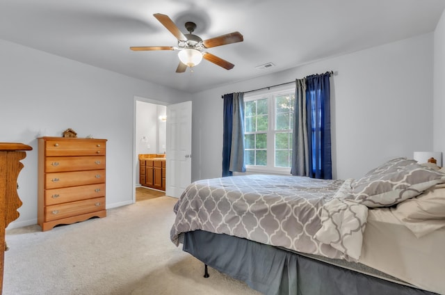 carpeted bedroom with ensuite bathroom and ceiling fan