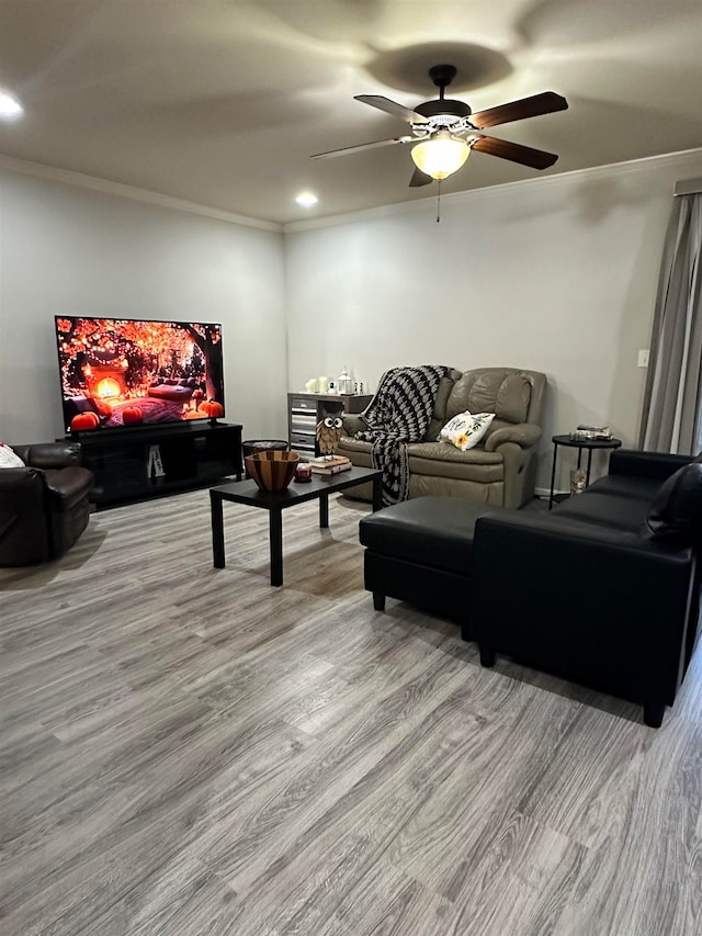 living room featuring crown molding, wood-type flooring, and ceiling fan