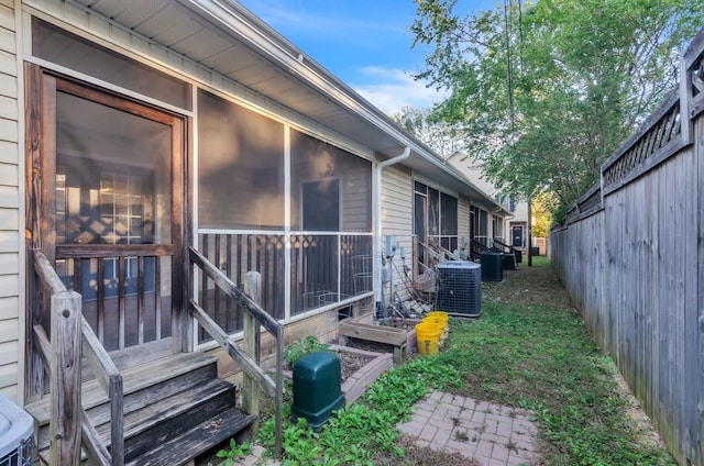 view of side of home with central AC and a sunroom