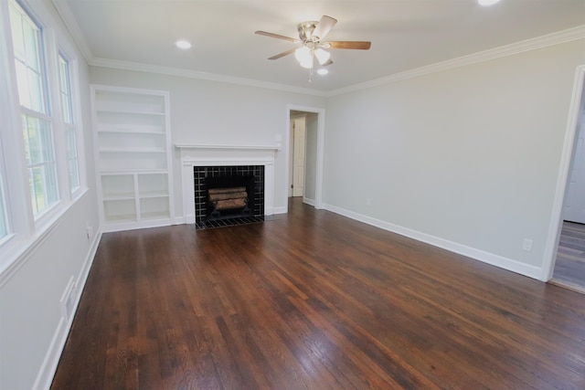 unfurnished living room with a fireplace, built in features, ceiling fan, dark wood-type flooring, and ornamental molding