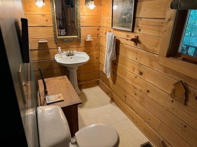 bathroom with toilet and wooden walls