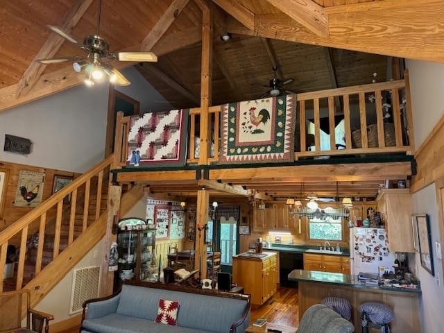 living room featuring beamed ceiling, hardwood / wood-style floors, high vaulted ceiling, and wooden ceiling