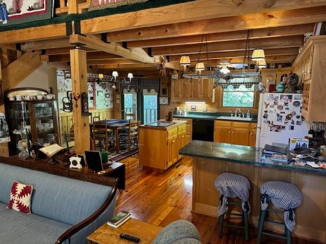 kitchen with sink, a center island, black dishwasher, white refrigerator, and hardwood / wood-style floors