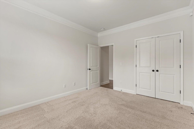 unfurnished bedroom featuring a closet, ornamental molding, and light colored carpet