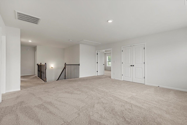 unfurnished room featuring light colored carpet