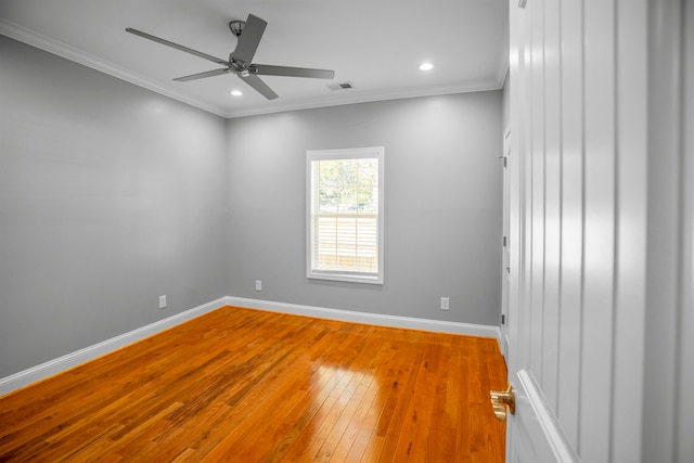 empty room featuring ceiling fan, hardwood / wood-style flooring, and crown molding