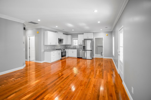 kitchen featuring white cabinetry, light hardwood / wood-style floors, appliances with stainless steel finishes, and a wealth of natural light