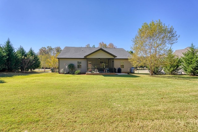 rear view of property with a sunroom and a lawn