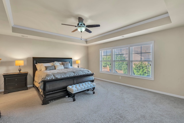 bedroom with light carpet, ceiling fan, and a raised ceiling