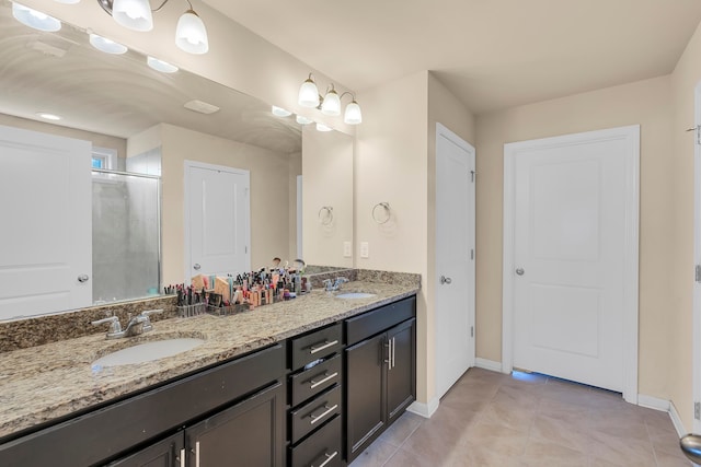 bathroom with a shower with door, tile patterned floors, and vanity