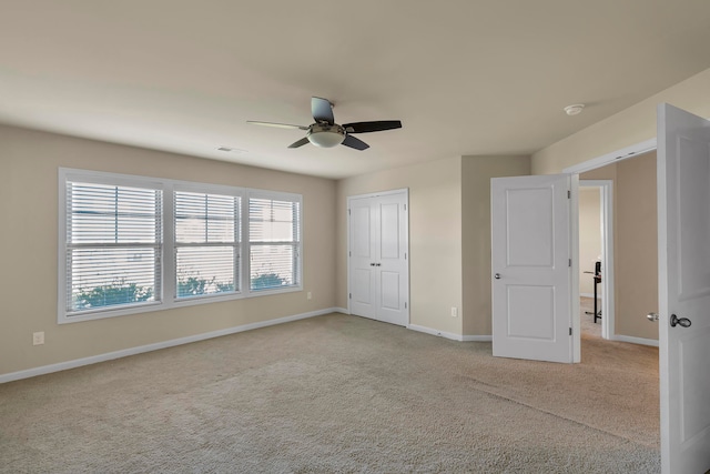 unfurnished bedroom featuring light colored carpet, a closet, and ceiling fan