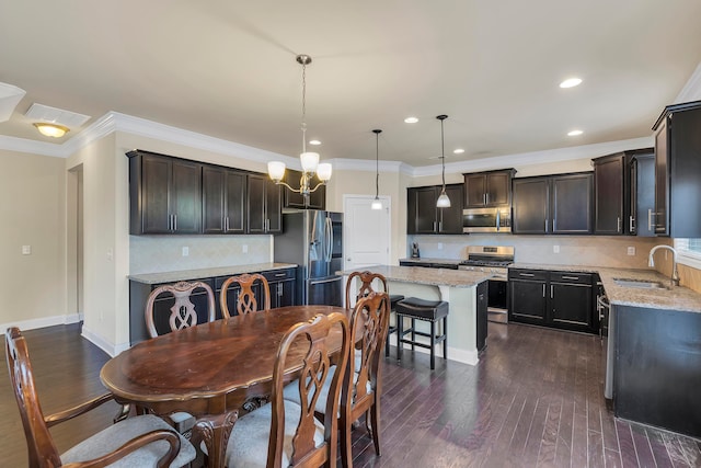 dining area featuring sink, a notable chandelier, crown molding, and dark hardwood / wood-style flooring