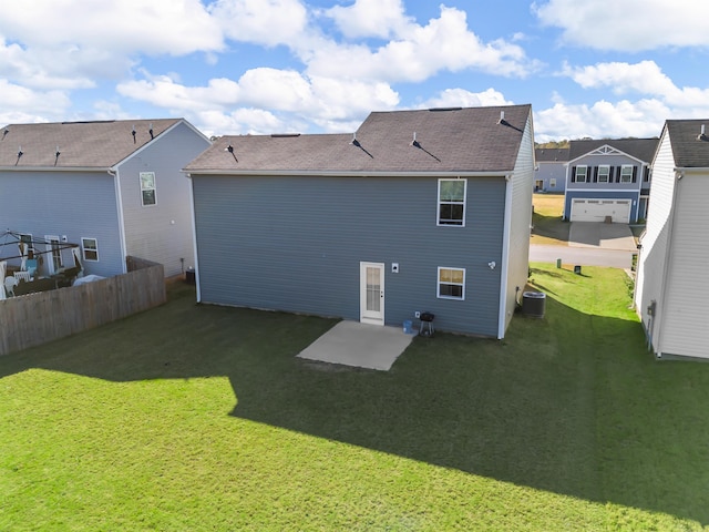 rear view of property featuring central AC and a lawn