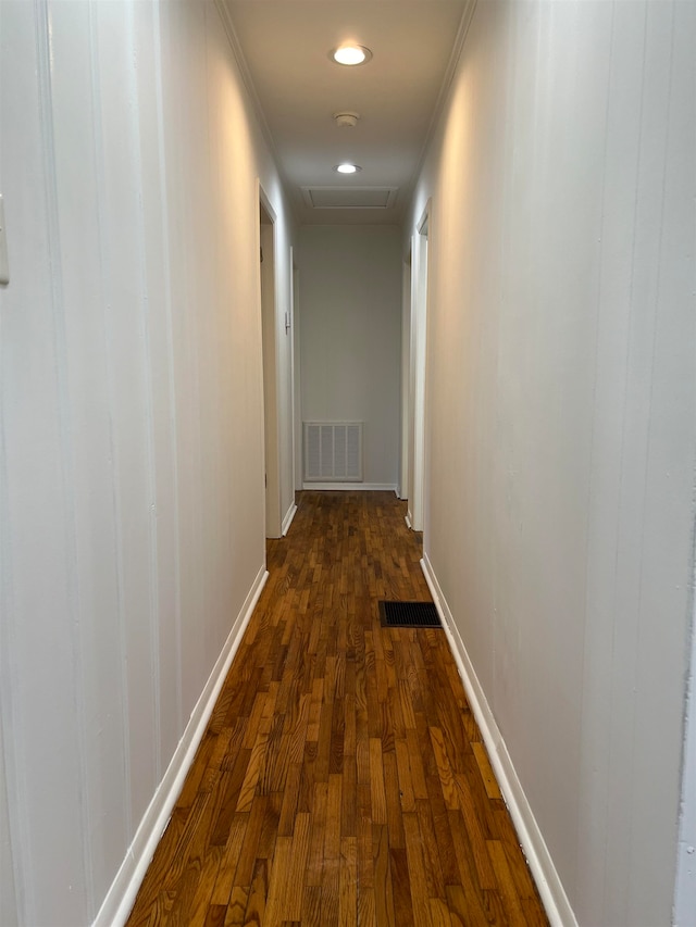 corridor with dark wood-type flooring and crown molding