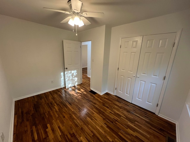 unfurnished bedroom featuring dark hardwood / wood-style floors, a closet, and ceiling fan