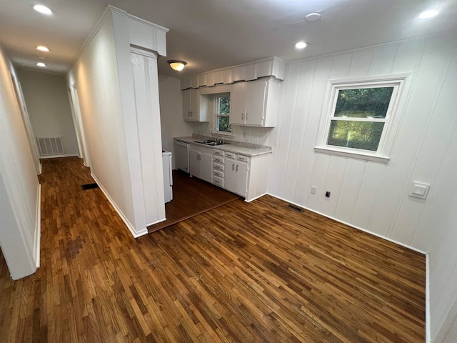 kitchen featuring stainless steel dishwasher, sink, dark wood-type flooring, and white cabinets