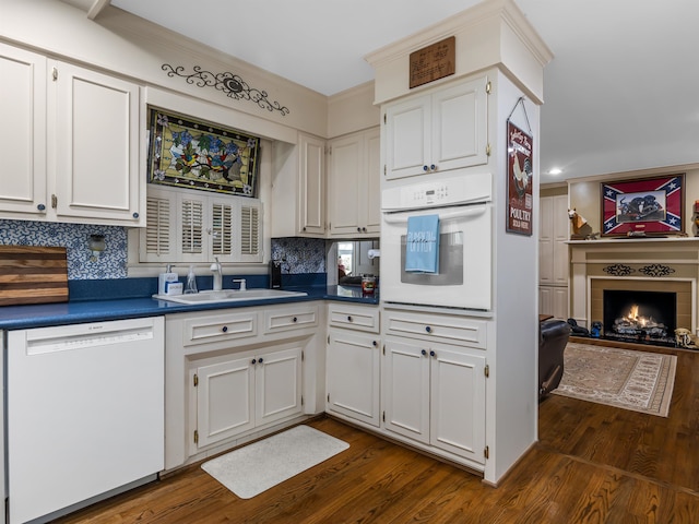 kitchen with dark hardwood / wood-style flooring, white cabinetry, tasteful backsplash, and white appliances