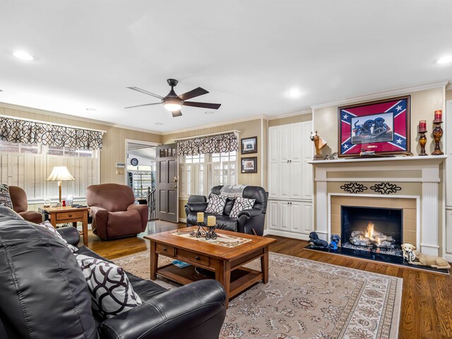 living room with ceiling fan, hardwood / wood-style flooring, and ornamental molding