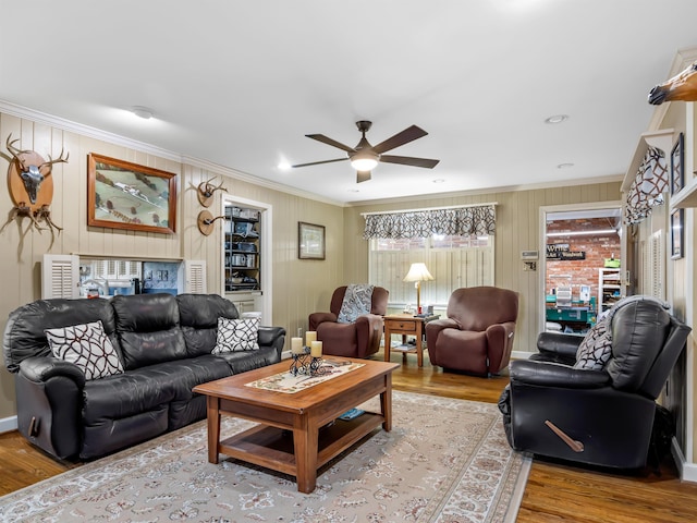 living room featuring ornamental molding, light hardwood / wood-style flooring, and ceiling fan