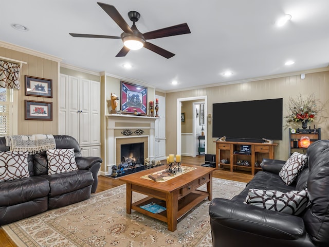 living room featuring light hardwood / wood-style floors, ornamental molding, built in features, and ceiling fan