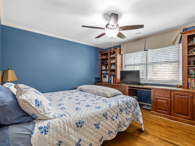 bedroom with built in desk, ceiling fan, ornamental molding, and light hardwood / wood-style floors