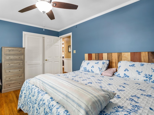 bedroom with a closet, crown molding, hardwood / wood-style floors, and ceiling fan