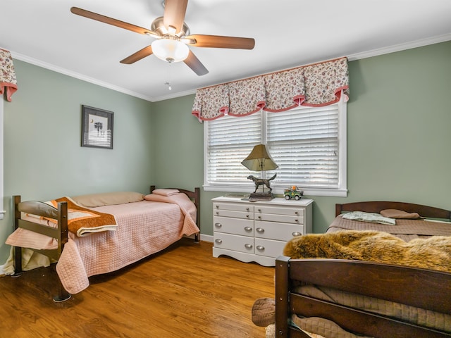 bedroom with light hardwood / wood-style flooring, crown molding, and ceiling fan