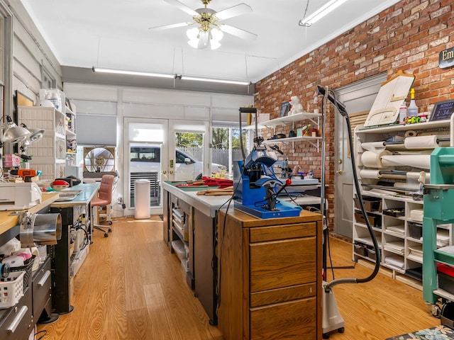 kitchen featuring light hardwood / wood-style flooring, brick wall, and ceiling fan