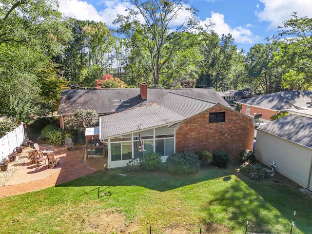 back of house with a patio and a lawn