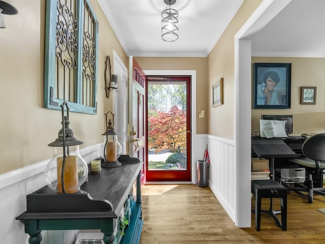 doorway with ornamental molding and light wood-type flooring