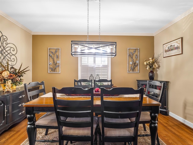 dining area with a notable chandelier, ornamental molding, and hardwood / wood-style flooring