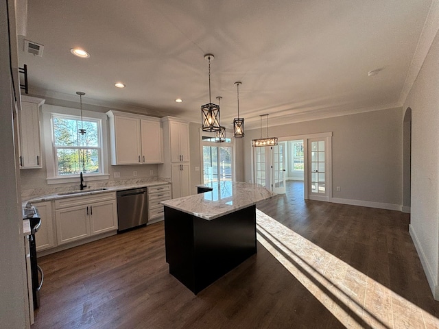 kitchen featuring white cabinetry, stainless steel appliances, a center island, and plenty of natural light