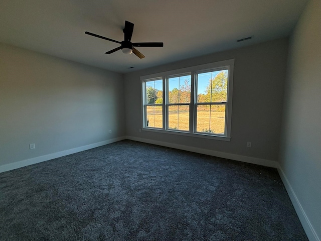 unfurnished room featuring ceiling fan and dark colored carpet