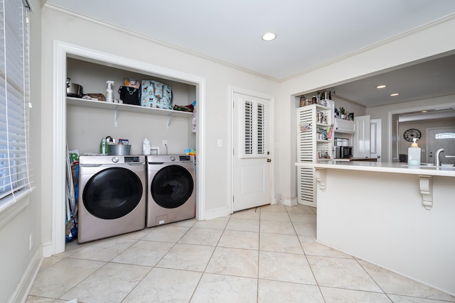 washroom featuring independent washer and dryer, ornamental molding, sink, and light tile patterned floors