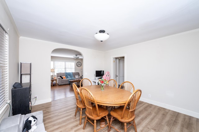 dining area with light hardwood / wood-style floors and ornamental molding