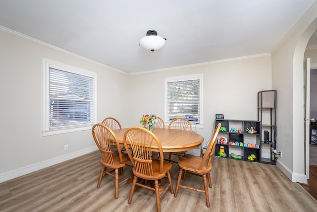 dining space featuring ornamental molding and light hardwood / wood-style flooring