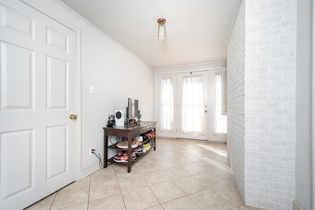 foyer entrance featuring crown molding and light tile patterned flooring