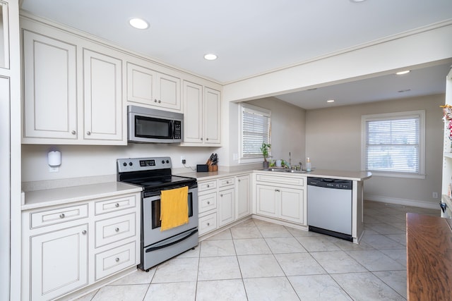 kitchen with appliances with stainless steel finishes, light tile patterned flooring, sink, kitchen peninsula, and white cabinetry