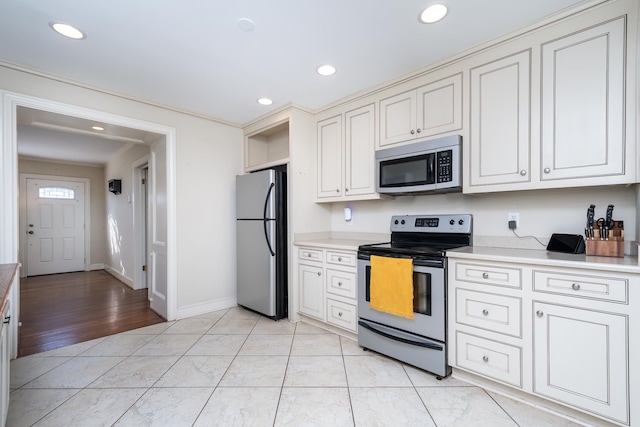 kitchen with crown molding, appliances with stainless steel finishes, and light hardwood / wood-style flooring