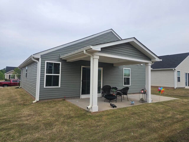 rear view of house featuring a patio and a yard