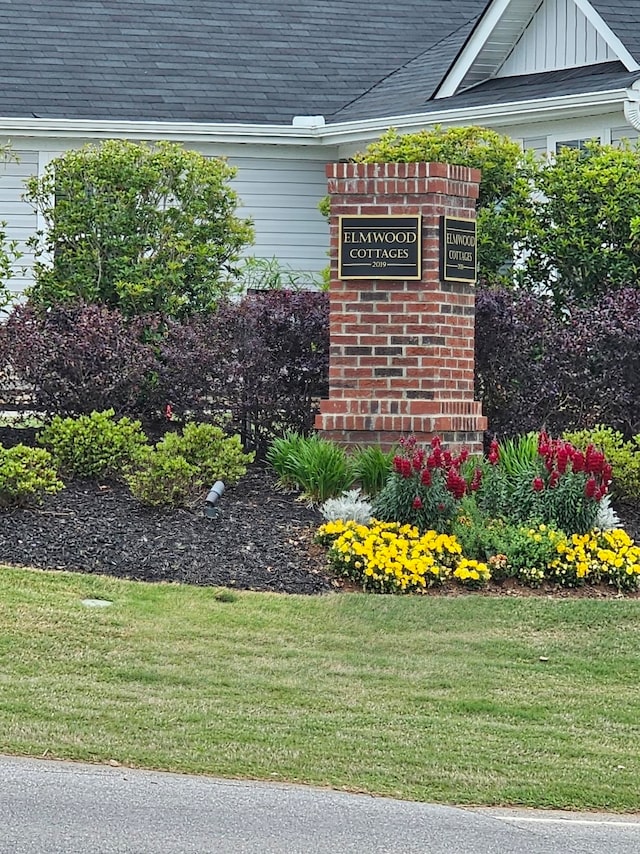 community / neighborhood sign with a yard