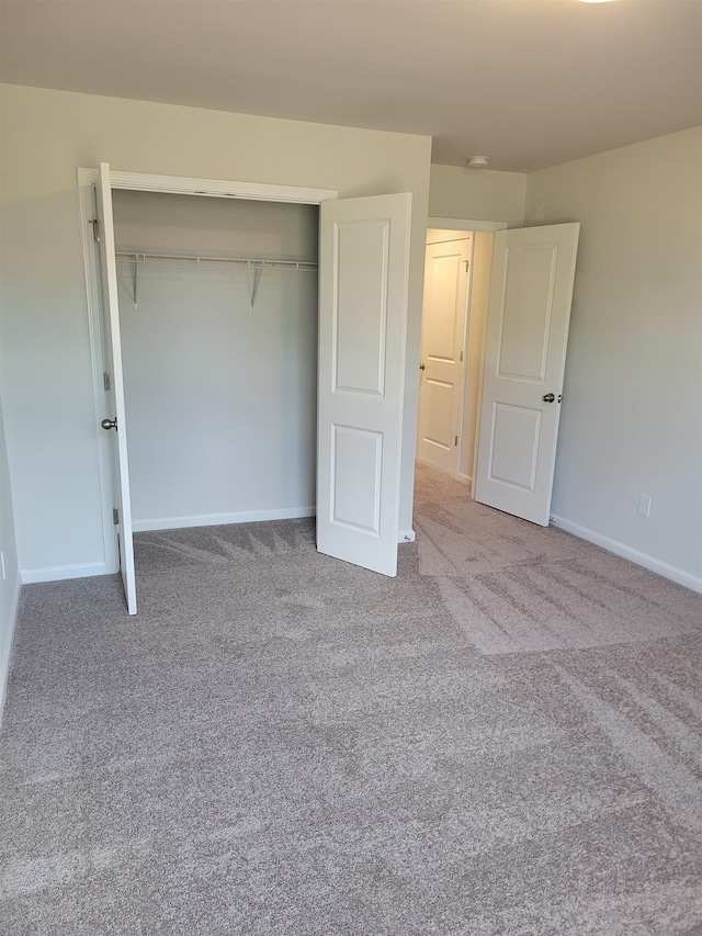 unfurnished bedroom featuring carpet and a closet